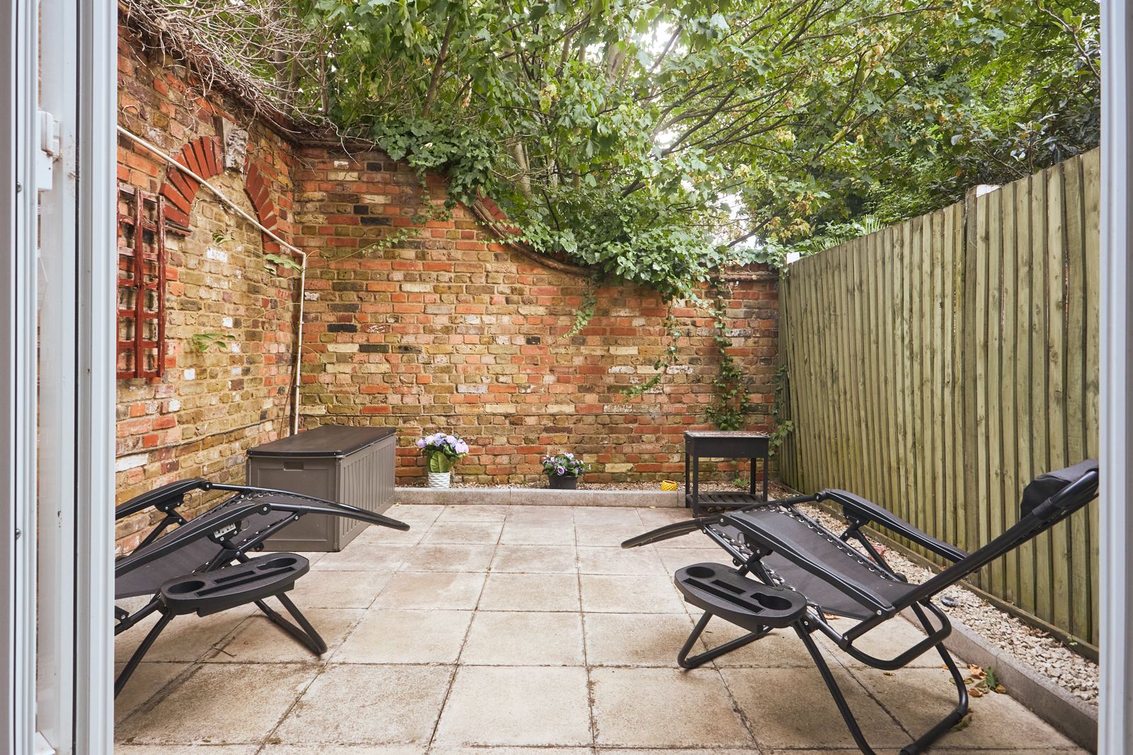 Walled garden with recliners and BBQ