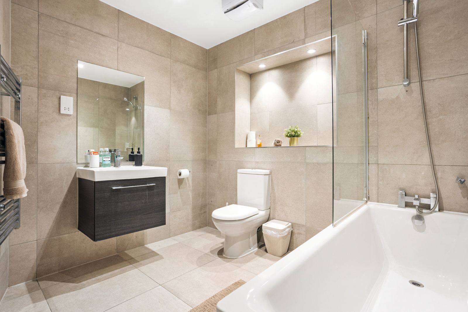 Bathroom with bath and lit shelf