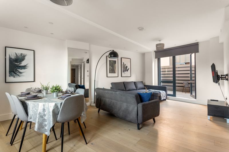 Open-plan living and dining room with doors open to the terrace